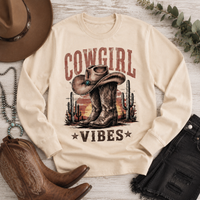Cowgirl Vibes western graphic apparel featuring cowboy boots, cowgirl hat, cacti and desert sunset design