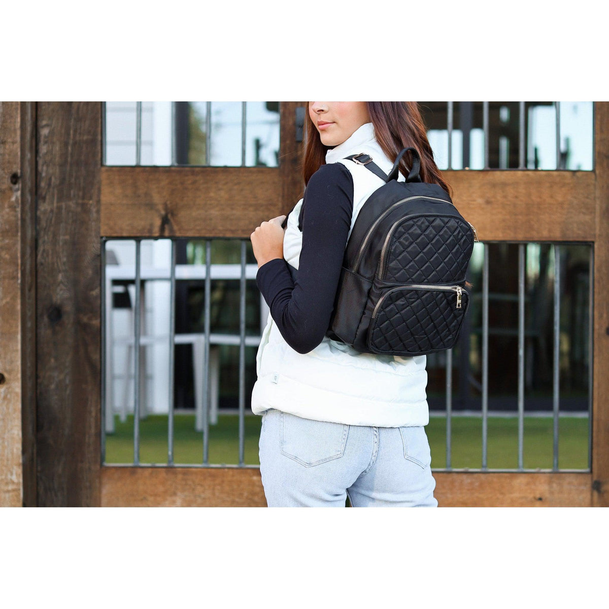 black quilted backpack with gold zipper detail worn by woman stylish everyday backpack