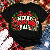 Merry Christmas Y'all graphic apparel featuring vintage red, green, and cream lettering with a festive buffalo plaid bow, Christmas ornaments, pine greenery, and rustic holiday decorations. Southern Christmas graphic available in two colors and four styles, including short sleeve crewneck, V-neck, long sleeve, and hoodie.