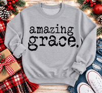 A light gray crewneck sweatshirt with the words 'amazing grace.' printed in a black distressed typewriter font.