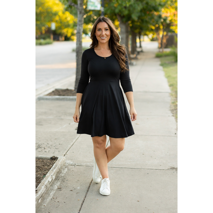 Black babydoll dress with 3/4 sleeves styled casually with sneakers