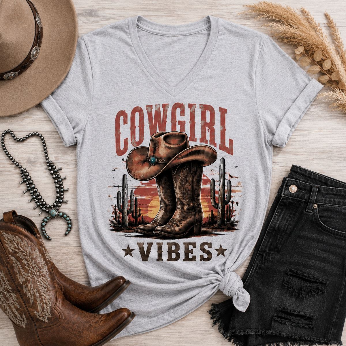 Cowgirl Vibes western graphic apparel featuring cowboy boots, cowgirl hat, cacti and desert sunset design