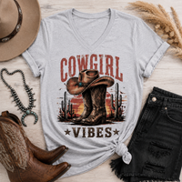Cowgirl Vibes western graphic apparel featuring cowboy boots, cowgirl hat, cacti and desert sunset design