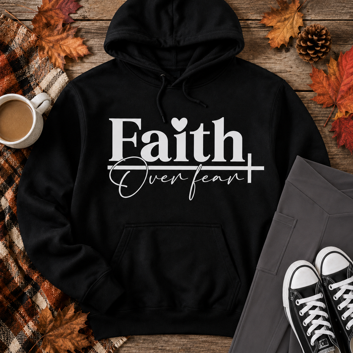 Black Faith Over Fear graphic hoodie styled in a fall flat lay with charcoal crossover pocket leggings, black sneakers, a plaid blanket, coffee, and autumn leaves.