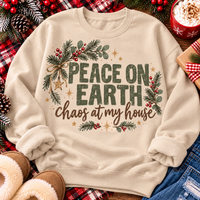 Peace on Earth Chaos at My House funny Christmas graphic apparel featuring distressed olive green lettering, rustic pine greenery, red berries and gold stars, available in sand and sport grey in short sleeve crewneck tees, V-neck tees, sweatshirts and hoodies.