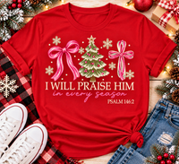 Christian Christmas shirt featuring I Will Praise Him in Every Season Psalm 146:2 graphic with pink bows, decorated Christmas tree, and cream snowflakes.