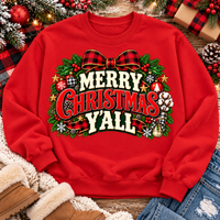 Merry Christmas Y'all graphic apparel featuring vintage red, green, and cream lettering with a festive buffalo plaid bow, Christmas ornaments, pine greenery, and rustic holiday decorations. Southern Christmas graphic available in two colors and four styles, including short sleeve crewneck, V-neck, long sleeve, and hoodie.