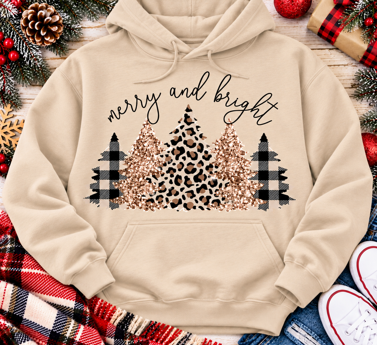 Merry and Bright Christmas graphic apparel featuring leopard print, buffalo plaid and glitter-inspired gold Christmas trees, available in three colors and four styles including crewneck tee, V-neck tee, sweatshirt and hoodie.
