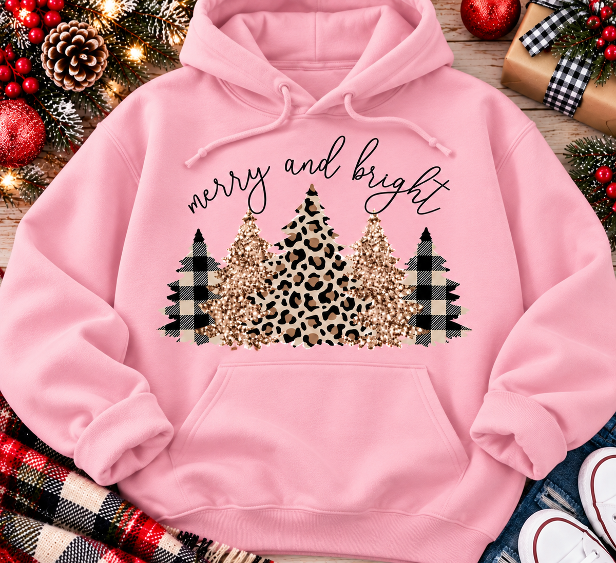 Merry and Bright Christmas graphic apparel featuring leopard print, buffalo plaid and glitter-inspired gold Christmas trees, available in three colors and four styles including crewneck tee, V-neck tee, sweatshirt and hoodie.