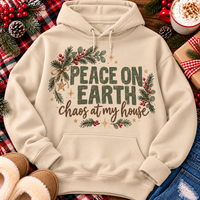 Peace on Earth Chaos at My House funny Christmas graphic apparel featuring distressed olive green lettering, rustic pine greenery, red berries and gold stars, available in sand and sport grey in short sleeve crewneck tees, V-neck tees, sweatshirts and hoodies.