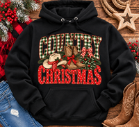 Country Christmas graphic tee with green plaid lettering, red polka dots, cowboy boots, western hat and festive Christmas bows.