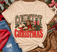 Country Christmas graphic tee with green plaid lettering, red polka dots, cowboy boots, western hat and festive Christmas bows.