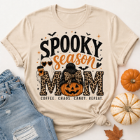 Beige Spooky Season Mom graphic tee featuring leopard print lettering, coffee ghost, jack-o'-lantern pumpkin, bats and Coffee Chaos Candy Repeat text.