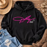 Black Dolly XOXO graphic hoodie featuring bright pink Dolly script with white XOXO and heart details, styled with distressed jeans and cowboy boots.